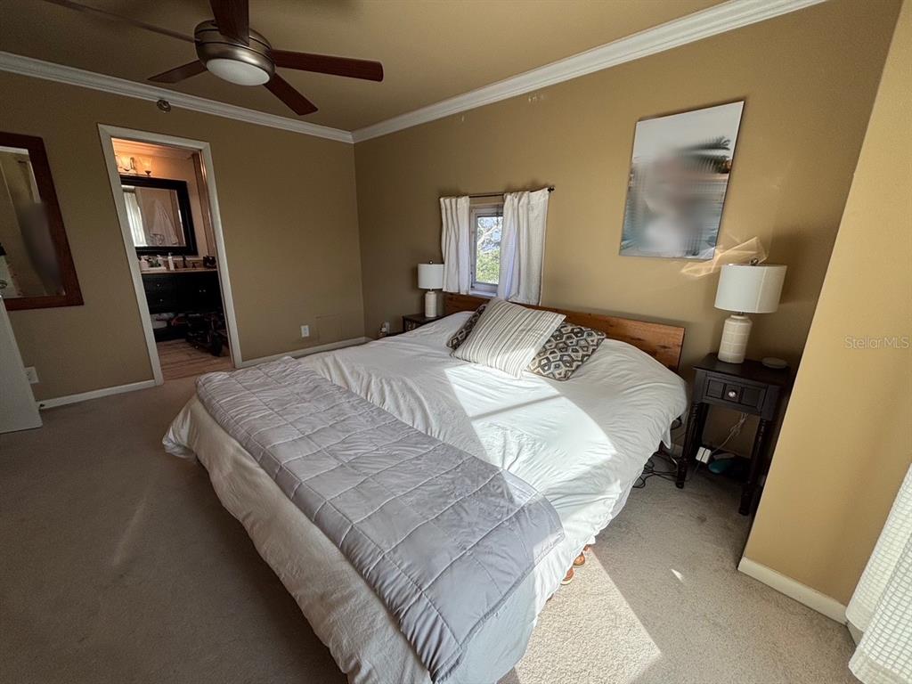 A bedroom features a bed with a gray quilt, two nightstands, and an attached bathroom — 4950 BAYSHORE BOULEVARD UNIT 28, TAMPA, FL