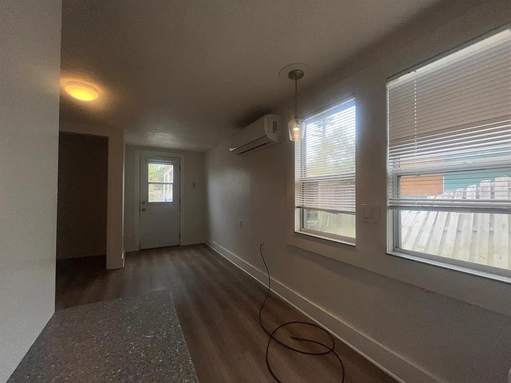 A room with wood-look flooring, a mini-split air conditioner, and two windows with blinds — 1713 29TH STREET W, BRADENTON, FL