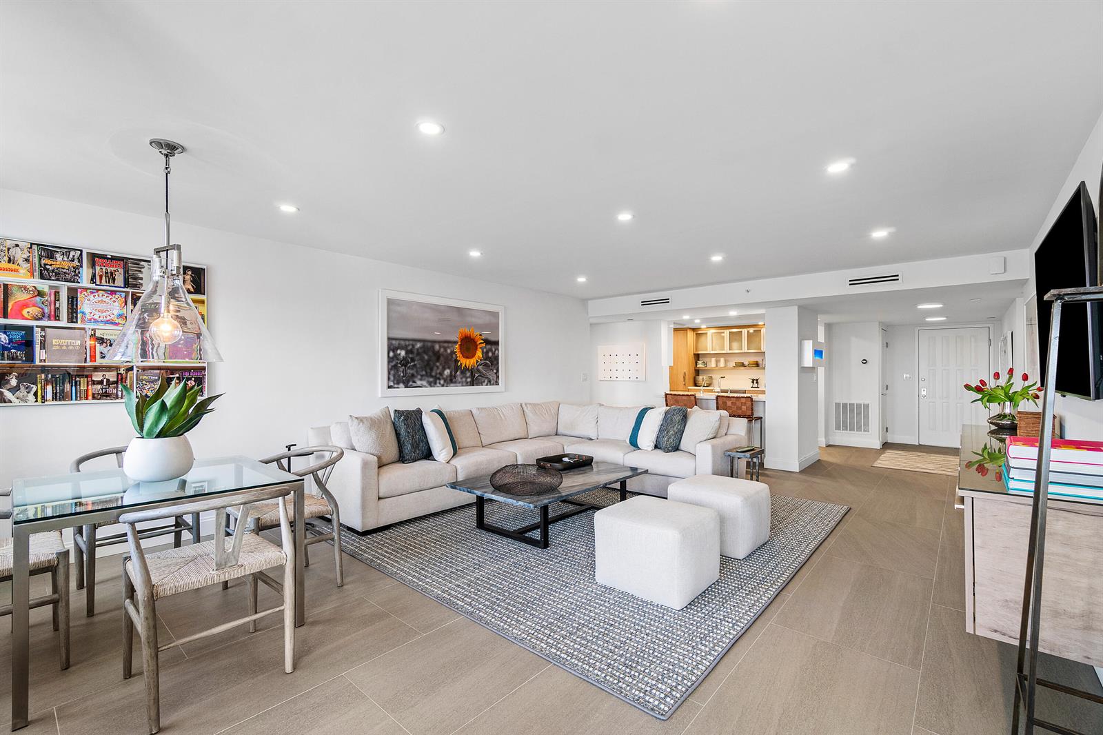 A modern living room features a sectional sofa, dining area, and open kitchen with bar seating — 3420 S Ocean Boulevard # 14x, Highland Beach FL 33487, HIGHLAND BEACH, FL
