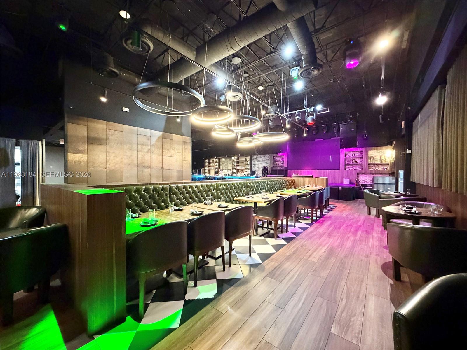 A modern restaurant interior features a long leather banquette, wooden tables, and checkered flooring — 4273 NW 41ST ST, Doral FL 33178, DORAL, FL