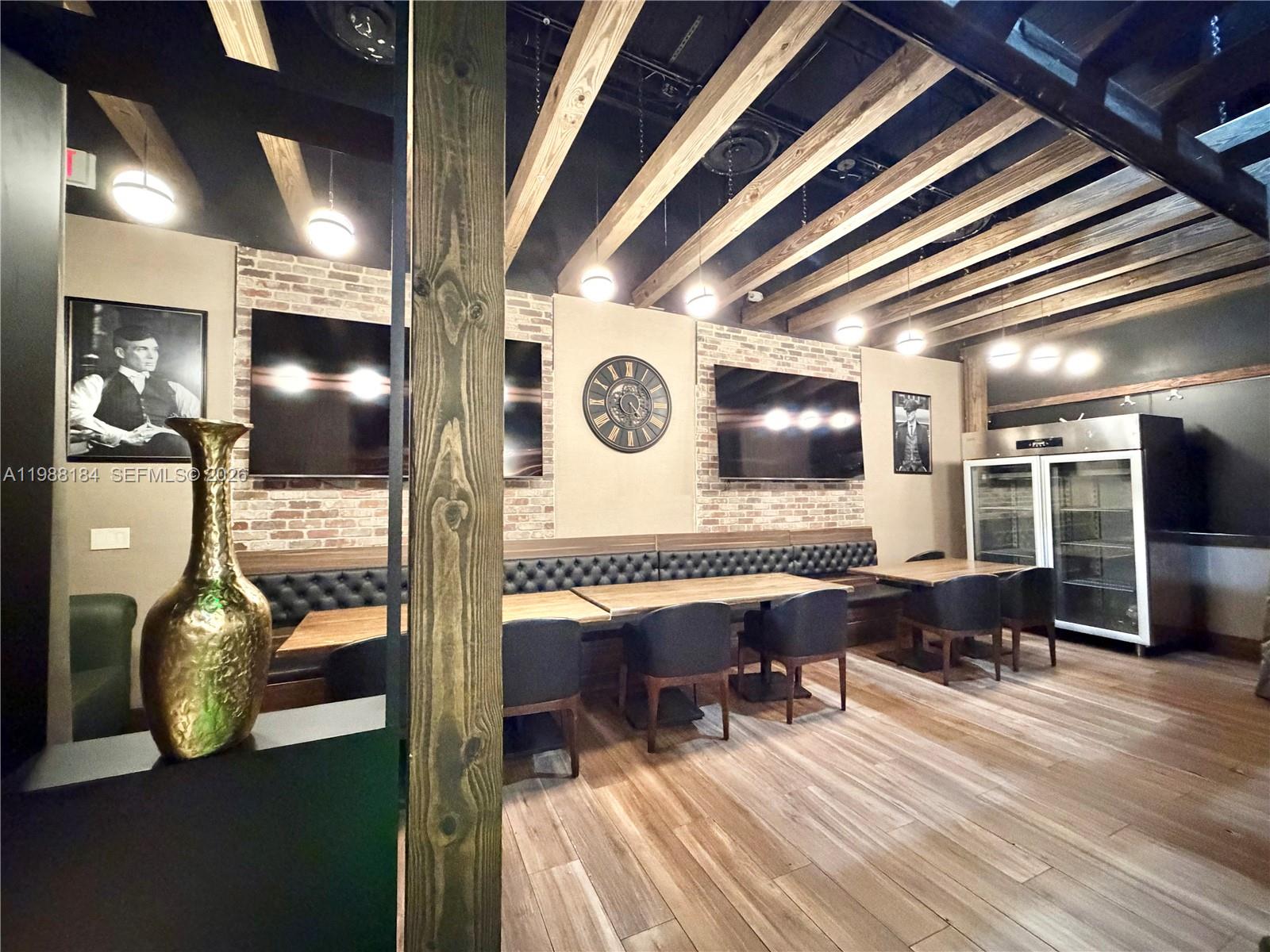 A modern restaurant interior features a long tufted booth, circular pendant lights, and wood flooring — 4273 NW 41ST ST, Doral FL 33178, DORAL, FL