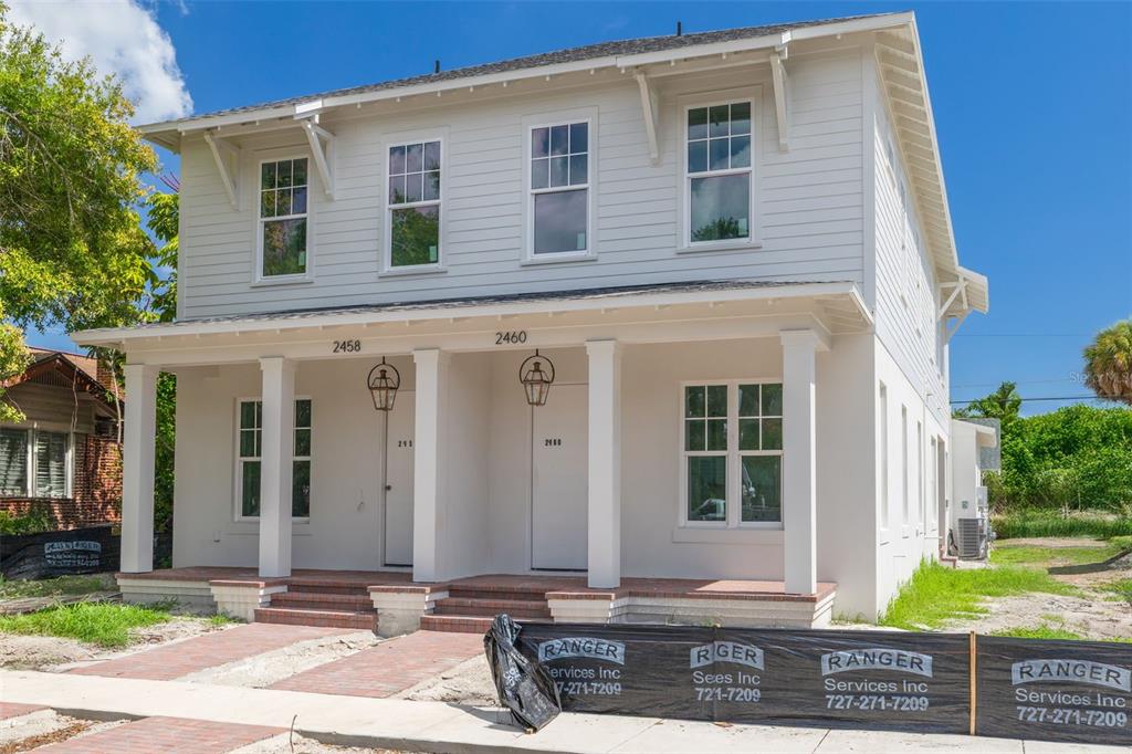 A two-story duplex with white siding, a front porch, and brick steps under construction — 2460 1ST AVENUE S, ST PETERSBURG, FL