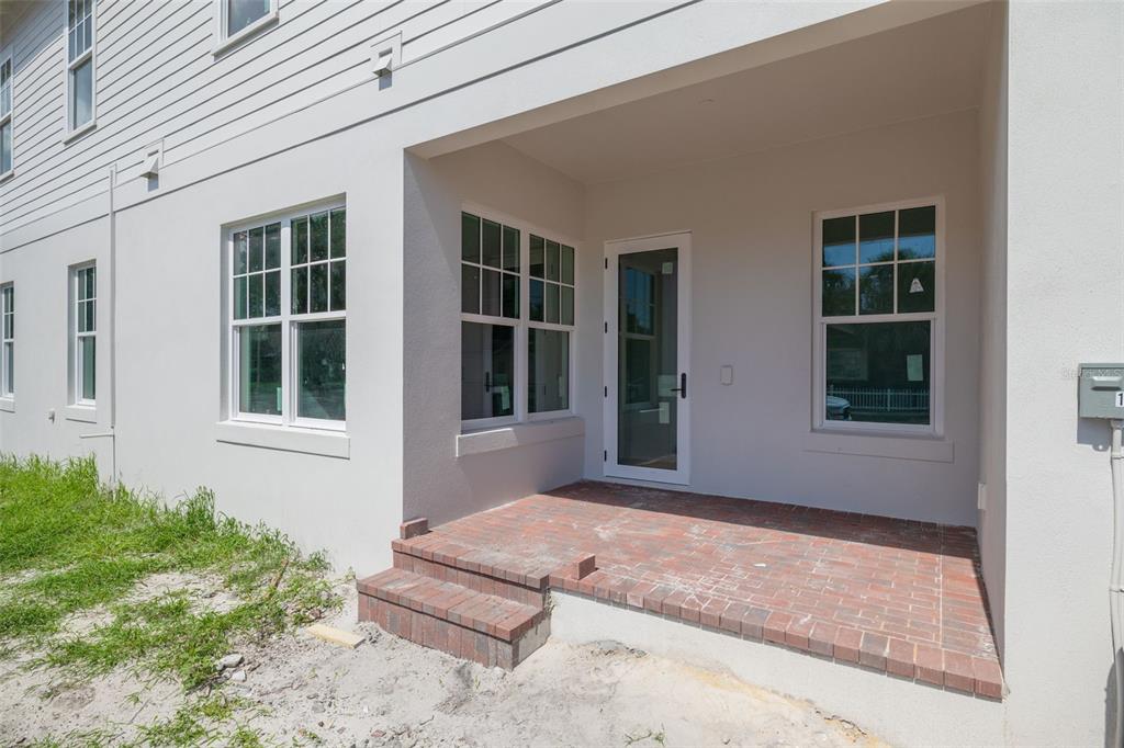 A brick patio with steps leads to a glass door on the side of a house — 2460 1ST AVENUE S, ST PETERSBURG, FL