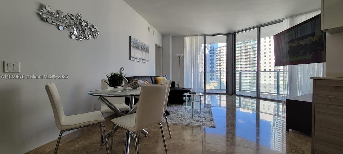 A modern living and dining area features tile floors, floor-to-ceiling windows, and city views — 1300 Brickell Bay Dr # 3007, Miami FL 33131, MIAMI, FL