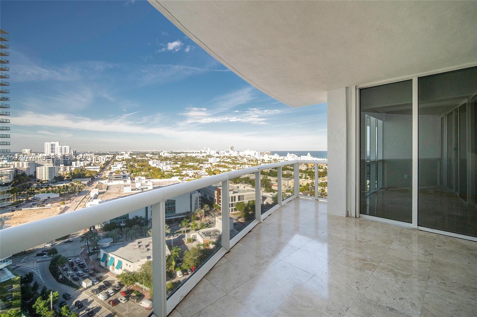 A high-rise balcony with marble flooring overlooks a city skyline and the ocean — 400 Alton Rd # 2309, Miami Beach FL 33139, MIAMI BEACH, FL