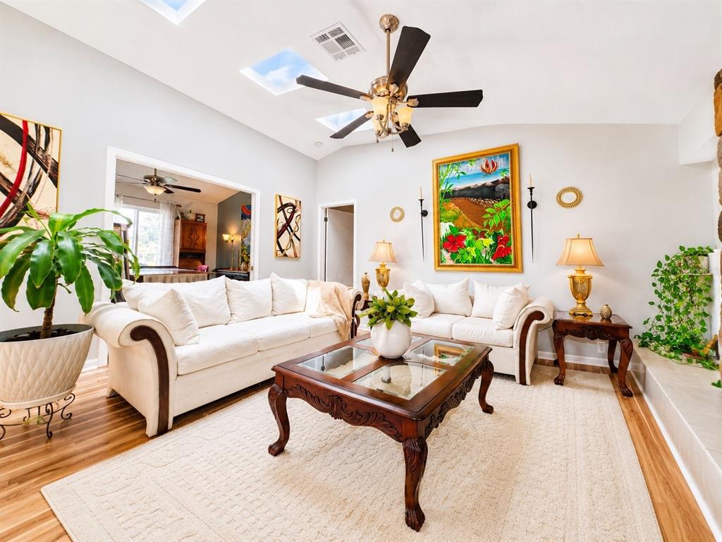 A living room with white sofas, a wooden coffee table, and skylights in the ceiling — 9801 DIDRIKSON DRIVE, NEW PORT RICHEY, FL