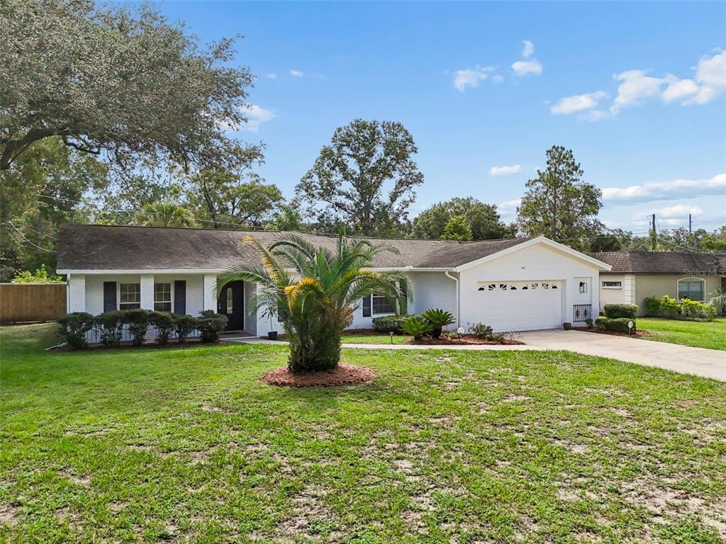 A single-story white house with a palm tree in the front yard and a garage — 507 ROLLINGVIEW DRIVE, TEMPLE TERRACE, FL