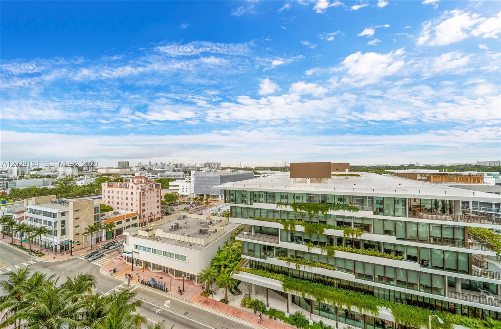 An elevated exterior view shows a modern multi-story building with greenery alongside surrounding city streets — 2301 Collins Ave # 1030, Miami Beach FL 33139, MIAMI BEACH, FL