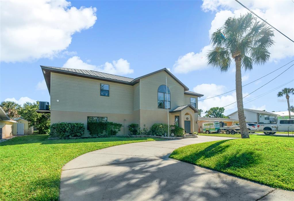 A two-story house with light-colored siding and a concrete driveway under a blue sky — 2050 NW 18TH STREET, CRYSTAL RIVER, FL