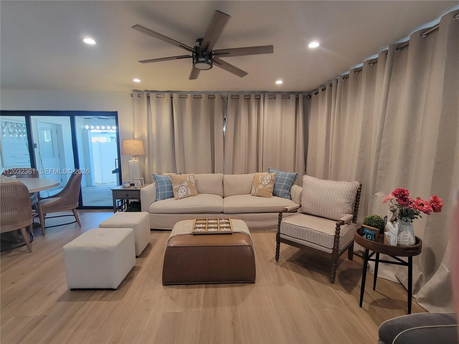 A living room features a beige sofa, a leather ottoman, and a striped armchair — 11339 5th Avenue Ocean, Marathon FL 33050, MARATHON, FL