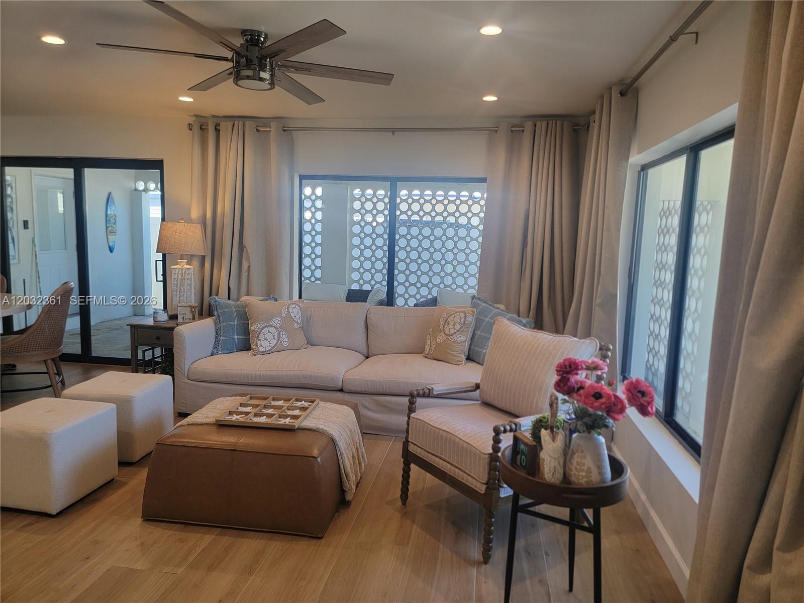 A living room features a light-colored sofa, a leather ottoman, and a patterned armchair — 11339 5th Avenue Ocean, Marathon FL 33050, MARATHON, FL