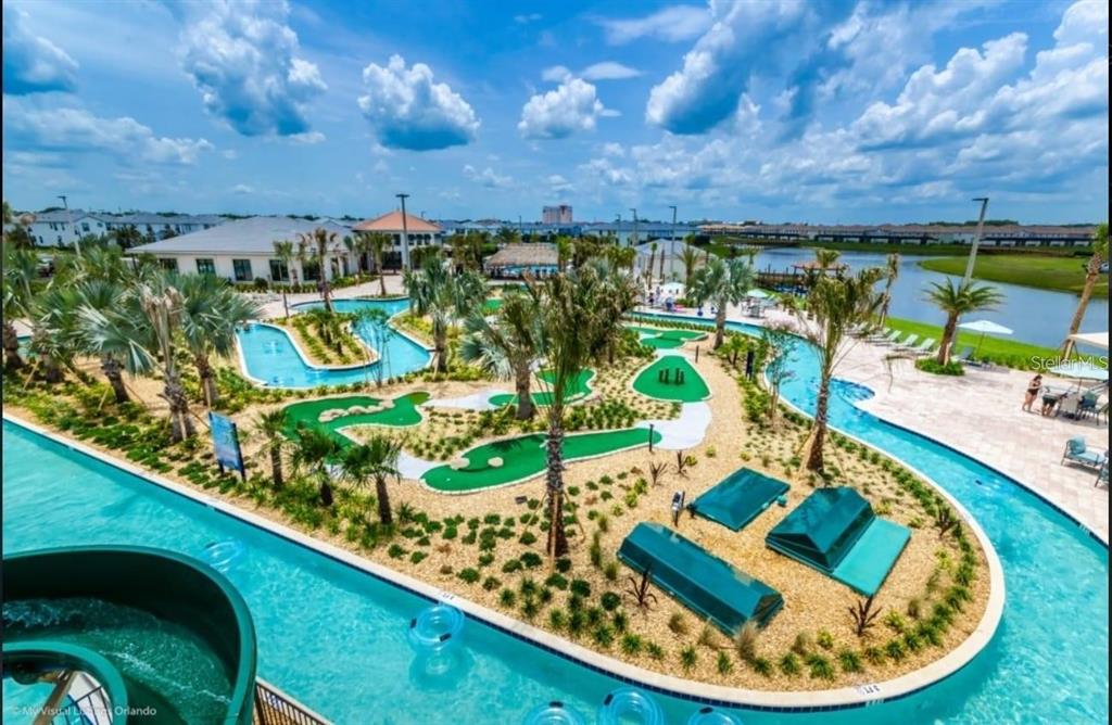 An aerial view of a resort-style swimming pool with a lazy river and putting green — 4741 CLOCK TOWER DRIVE UNIT 208, KISSIMMEE, FL