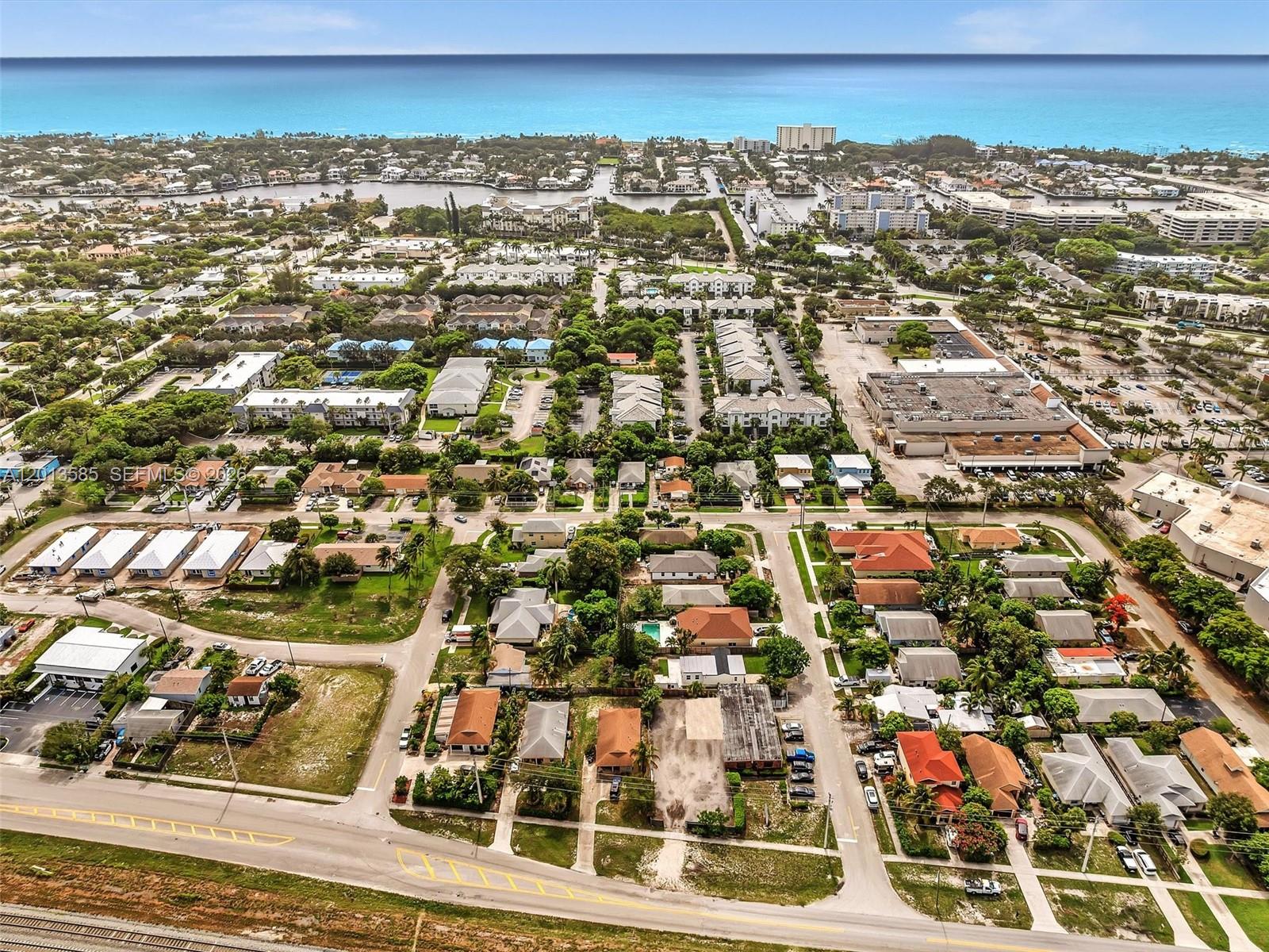 An aerial view shows a coastal neighborhood with houses, apartment complexes, and a nearby ocean — 107 Central Ave, Delray Beach FL 33483, DELRAY BEACH, FL