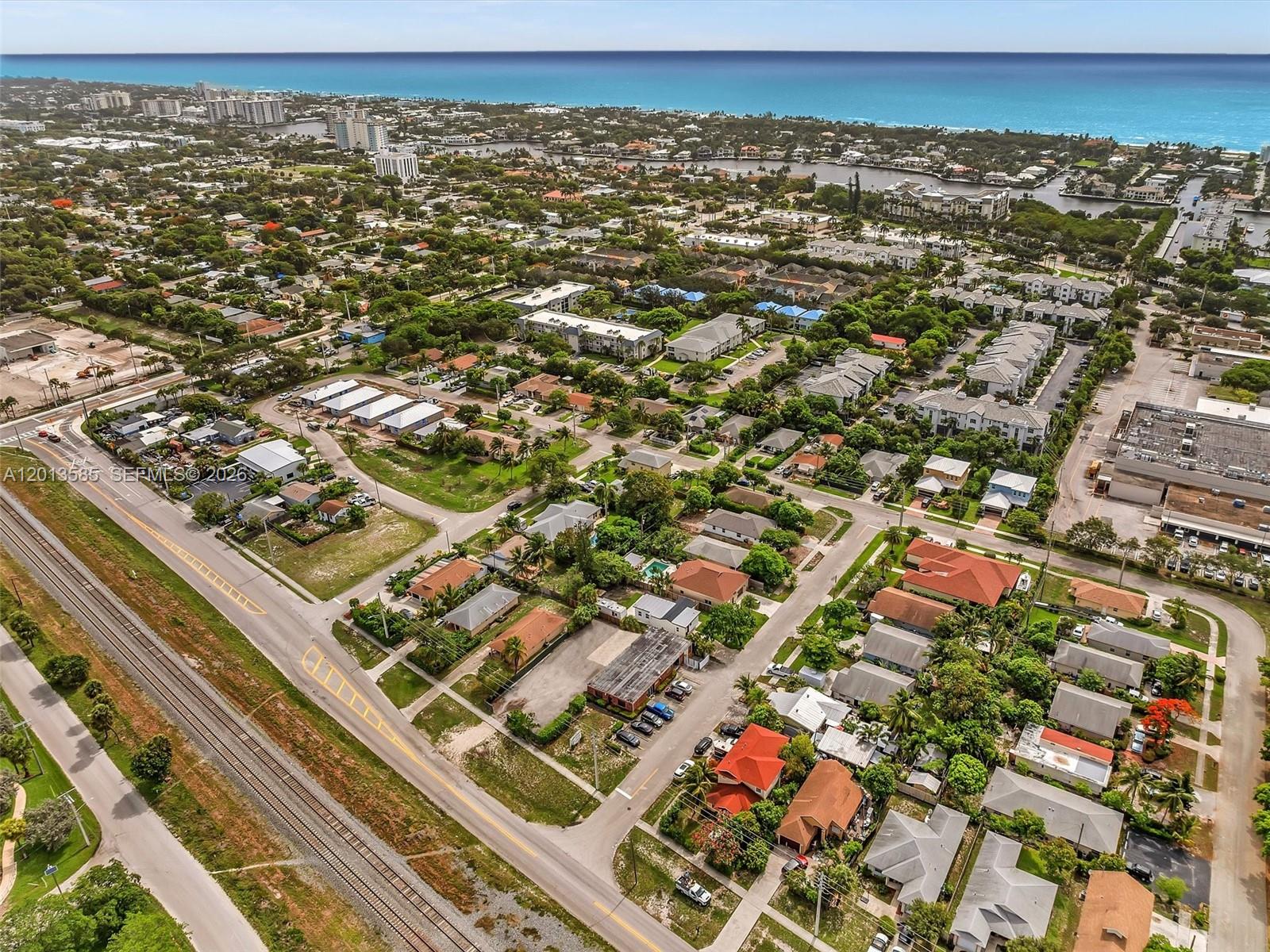 An aerial view shows a residential neighborhood near a railroad track and the ocean — 107 Central Ave, Delray Beach FL 33483, DELRAY BEACH, FL
