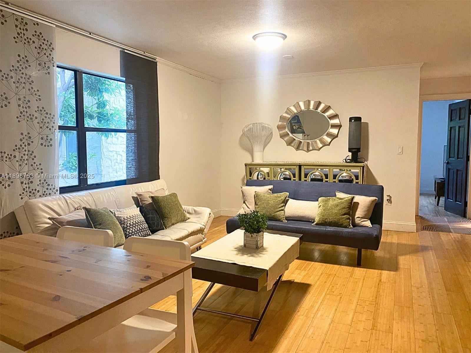 A living room features a white sofa, a blue futon, and light wood flooring — 753 Michigan Ave # 2B, Miami Beach FL 33139, MIAMI BEACH, FL