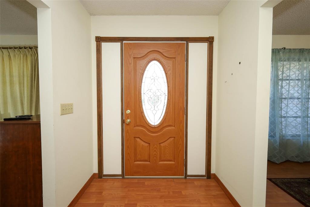 A front entryway features a wood-toned door with a glass oval insert and laminate flooring — 504 RIDGEWOOD STREET, ALTAMONTE SPRINGS, FL