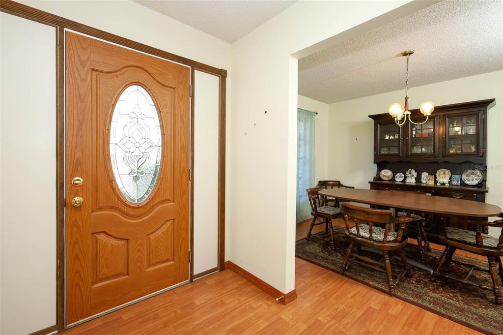 An entryway with a wood-paneled door leads into a dining room with a wooden hutch — 504 RIDGEWOOD STREET, ALTAMONTE SPRINGS, FL