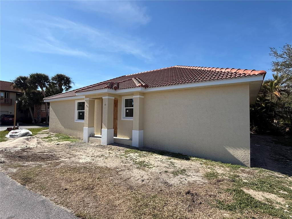 A single-story house with a tan stucco exterior and a red tile roof — 0 SORRENTO PLACE, NOKOMIS, FL