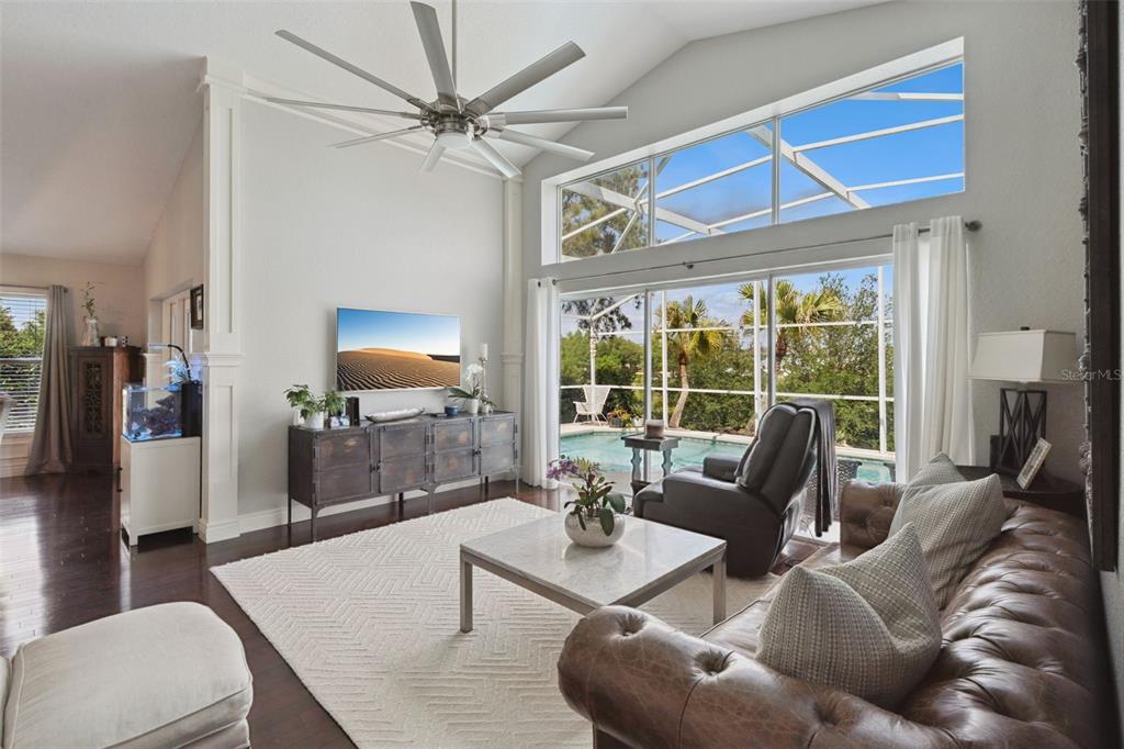 A living room features a vaulted ceiling, a large ceiling fan, and sliding glass doors — 112 WINDSOR PLACE, DAVENPORT, FL