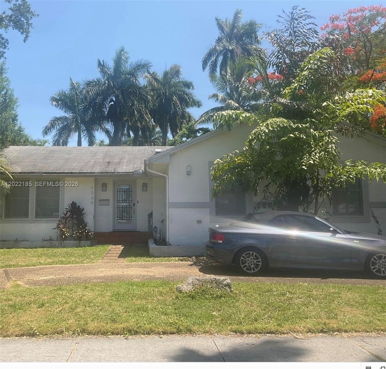A single-story white house with a gray roof and a car parked in front — 1206 Tyler St, Hollywood FL 33019, HOLLYWOOD, FL