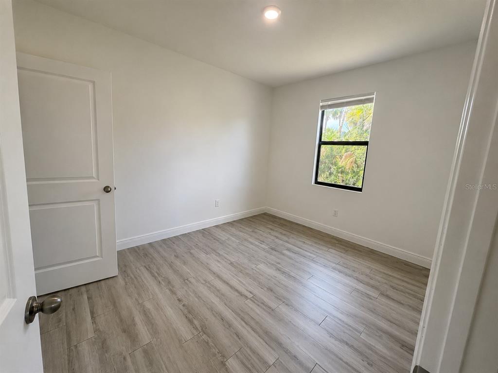 An empty bedroom features light wood-look tile flooring, white walls, and a single window — 3117 MEMPHIS LANE, LABELLE, FL