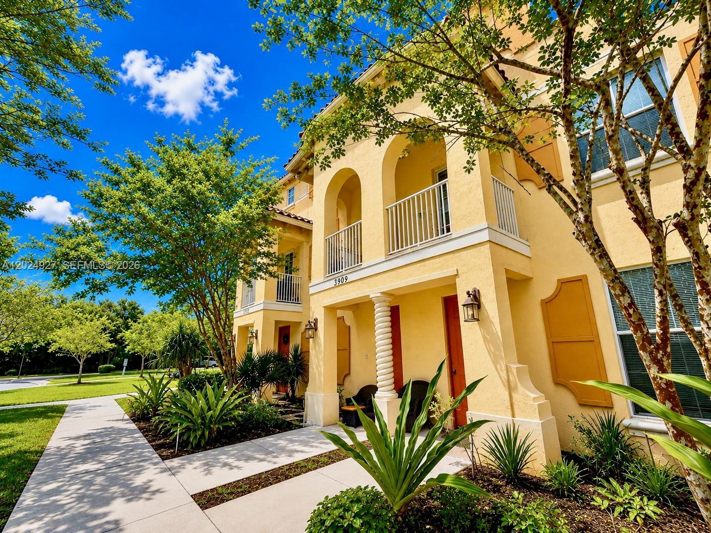 A yellow two-story building features arched balconies, a covered entryway, and a concrete walkway — 3909 White Peacock Ln, Coconut Creek FL 33073, COCONUT CREEK, FL