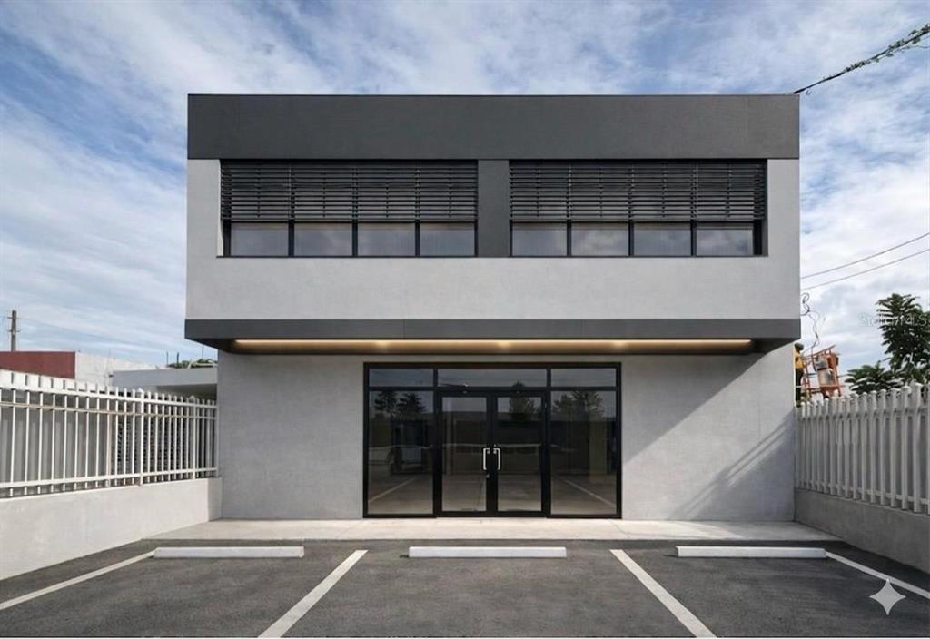 A modern two-story commercial building with a gray facade, glass entrance, and paved parking lot — PR-2 CANDELARIA BO ARENAS, TOA BAJA, PR