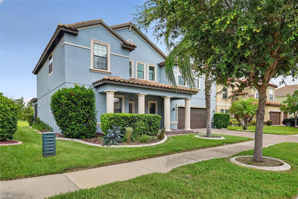 A two-story blue house with a covered front porch and a two-car garage — 11911 SAND MYRTLE ROAD, RIVERVIEW, FL
