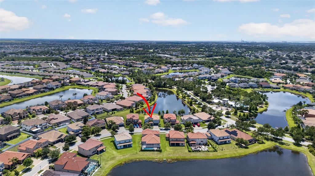 An aerial view shows a residential neighborhood with houses surrounding several ponds — 11911 SAND MYRTLE ROAD, RIVERVIEW, FL