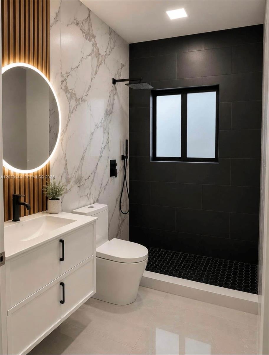 A modern bathroom features a white vanity, marble-look walls, and a black-tiled walk-in shower — 23041 SW 107th Ave # 2, Miami FL 33170, MIAMI, FL