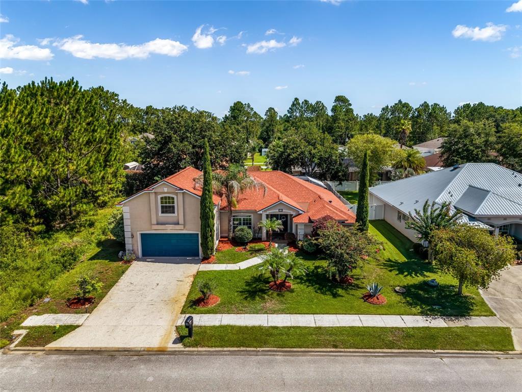 An aerial view of a single-story house with a red roof and a concrete driveway — 18 LEWISTON COURT, PALM COAST, FL