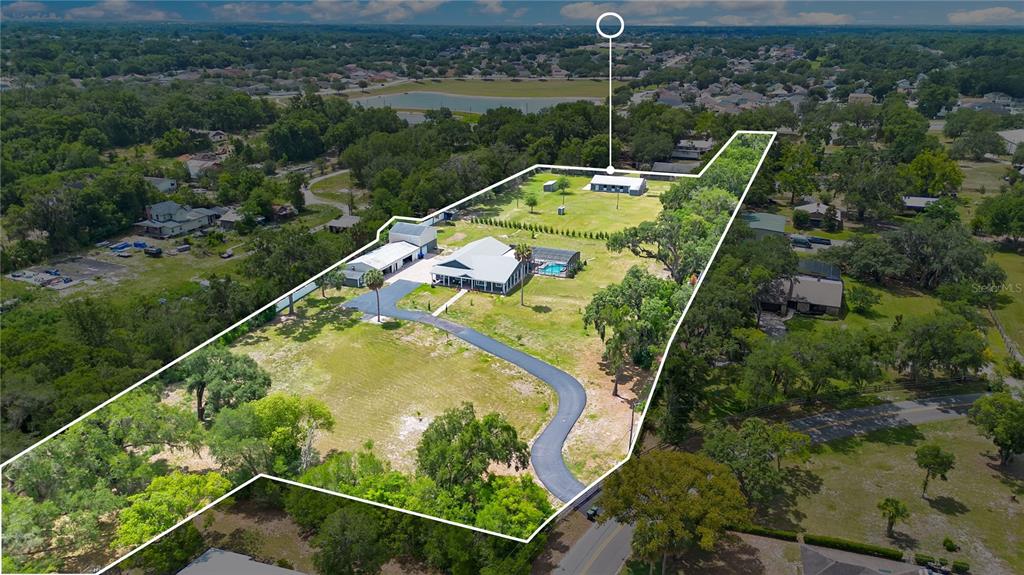 An aerial view shows a house with a pool, outbuildings, and a long driveway — 5785 GILLIAM ROAD, ORLANDO, FL