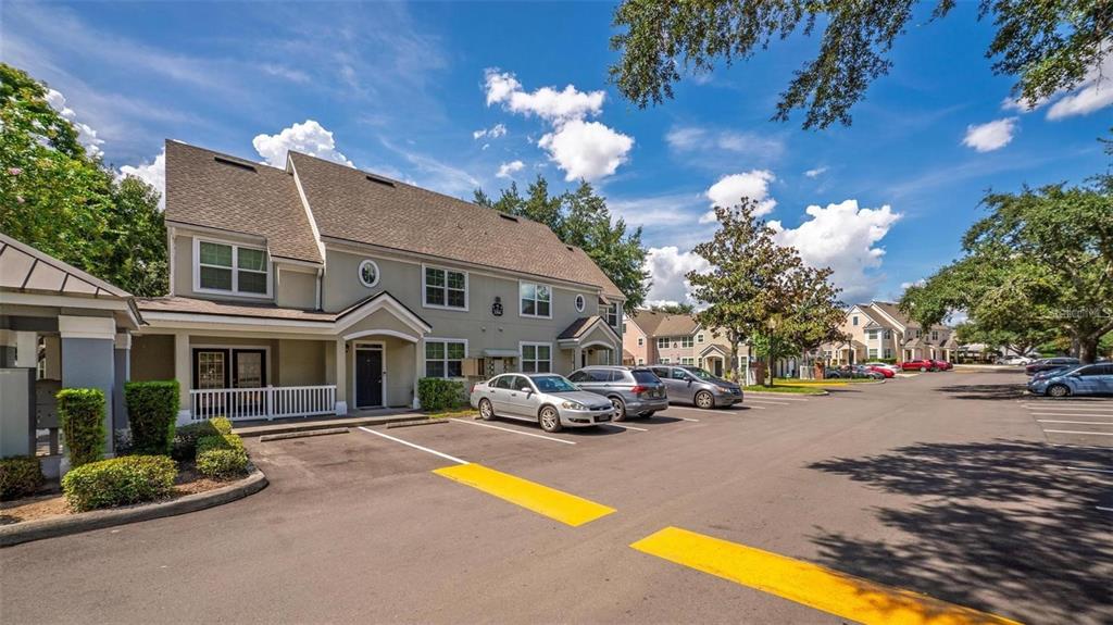 A multi-story residential building with a parking lot and several parked cars in front — 3396 PARKCHESTER SQUARE BOULEVARD UNIT 204, ORLANDO, FL