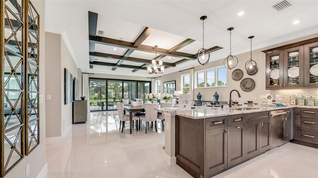 A modern kitchen and dining area feature dark wood cabinetry, coffered ceilings, and tile flooring — 1197 CRESSWIND BOULEVARD, DELAND, FL