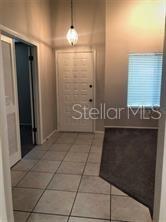 An entryway features a tiled floor, a white front door, and a carpeted living area — 467 NEWTON PLACE, LONGWOOD, FL