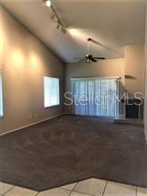 A living room with vaulted ceilings, carpeted flooring, a ceiling fan, and a fireplace — 467 NEWTON PLACE, LONGWOOD, FL