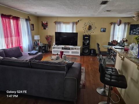 A living room features a dark gray sectional sofa, a television on a stand, and barstools — 6121 HOLIDAY HILL LANE, ORLANDO, FL