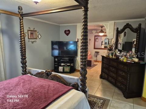 A bedroom features a four-poster bed, a television on a stand, and a wooden dresser — 6121 HOLIDAY HILL LANE, ORLANDO, FL