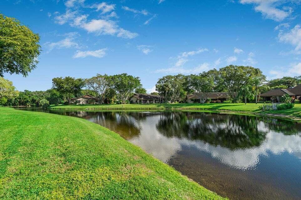 A grassy lawn slopes down to a pond in front of several residential buildings — 10092 Cedar Point Boulevard # 204, Boynton Beach FL 33437, BOYNTON BEACH, FL
