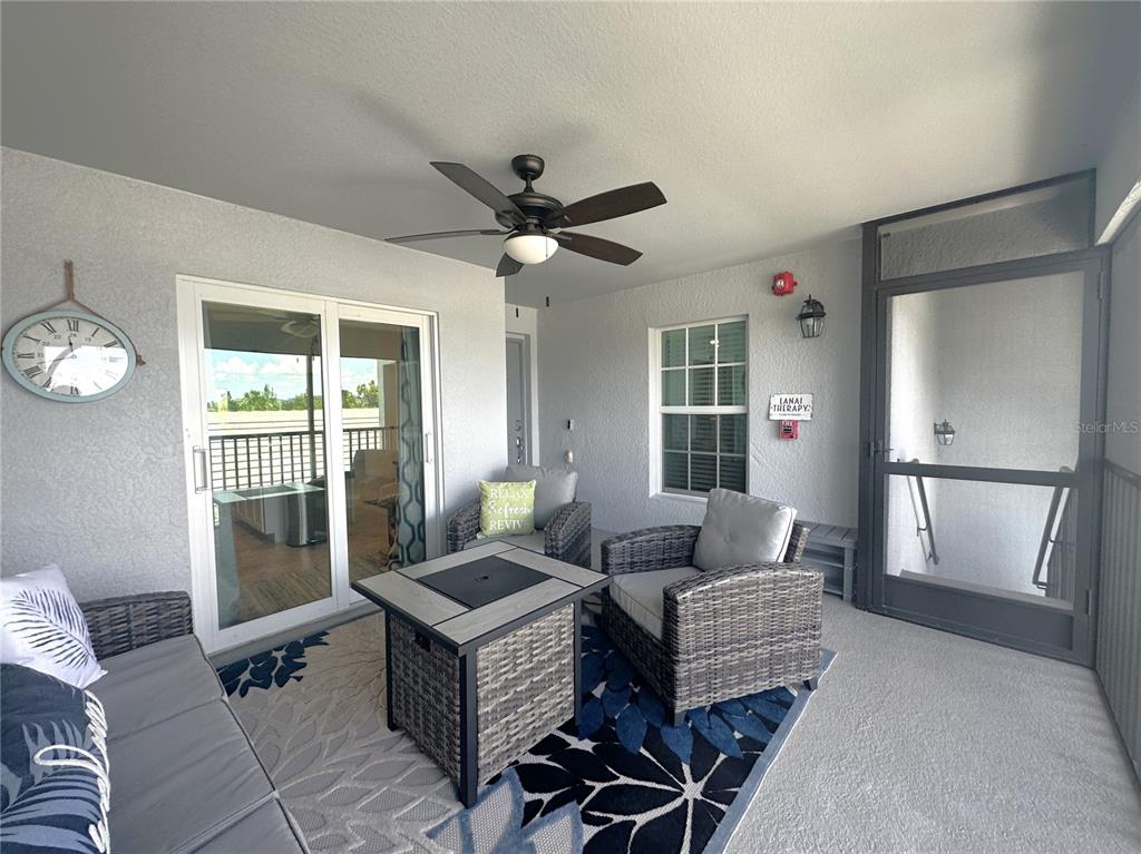 A covered patio features wicker furniture, a fire pit table, a ceiling fan, and screen doors — 14050 HERITAGE LANDING BOULEVARD UNIT 225, PUNTA GORDA, FL