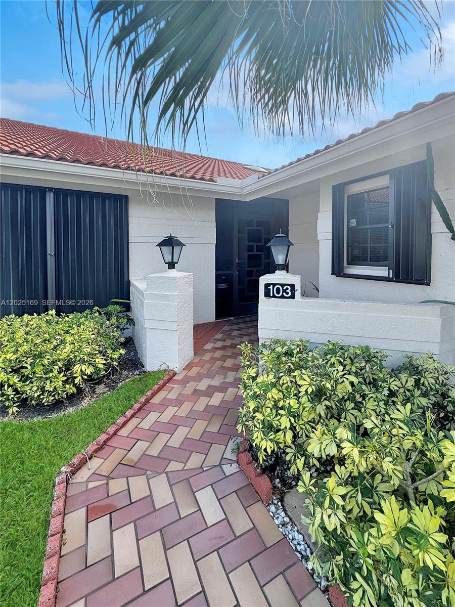 A brick walkway leads to the front entrance of a house with a tiled roof — 9699 Pavarotti Ter # 103, Boynton Beach FL 33437, BOYNTON BEACH, FL