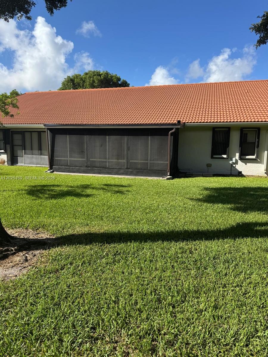 The exterior of a house features a screened-in patio and a terracotta-tiled roof — 9699 Pavarotti Ter # 103, Boynton Beach FL 33437, BOYNTON BEACH, FL