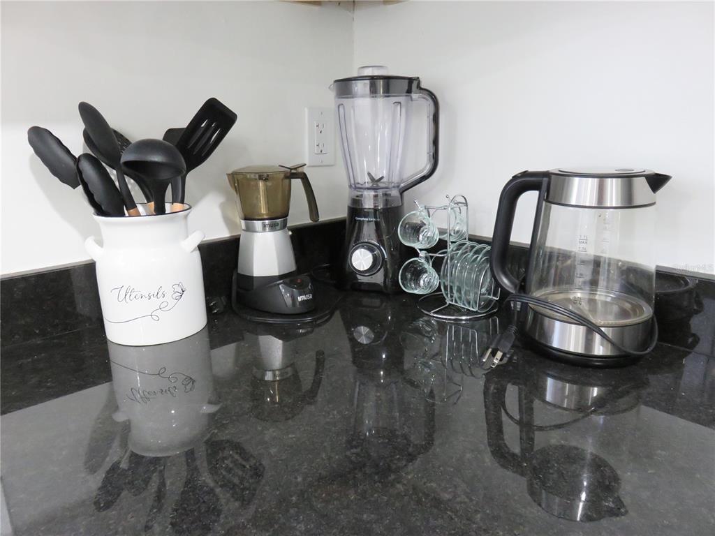 A kitchen counter features a utensil holder, a blender, a coffee maker, and an electric kettle — 5401 SWEETWATER TERRACE CIRCLE UNIT 5401, TAMPA, FL