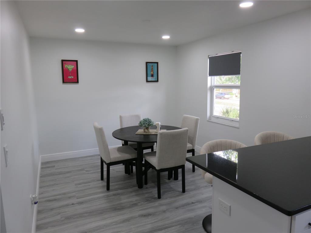 A dining area features a round table with four chairs, light flooring, and white walls — 5401 SWEETWATER TERRACE CIRCLE UNIT 5401, TAMPA, FL