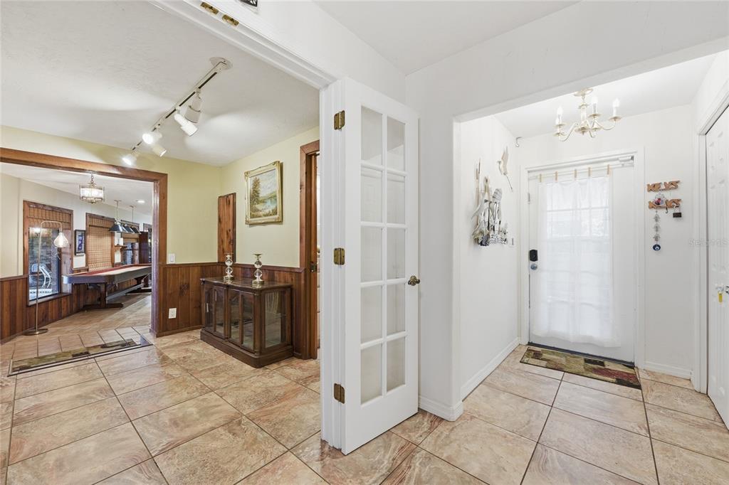 An entryway with tiled floors leads to a room containing a pool table — 200 WINDY POINT ROAD, LAKE PLACID, FL