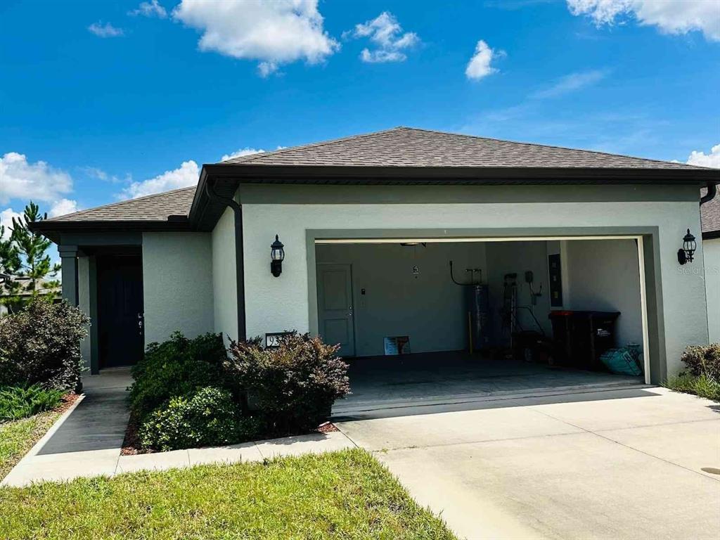 A single-story house exterior features a two-car garage, a covered entryway, and a concrete driveway — 9335 SW 53RD PLACE, OCALA, FL