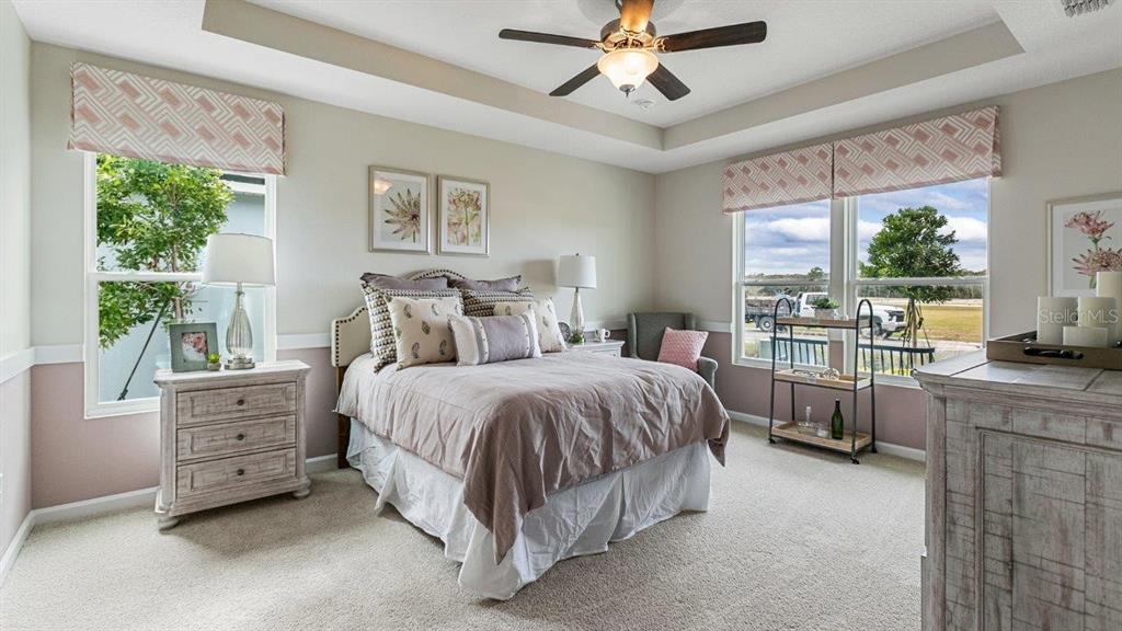 A bedroom features a queen bed, two windows with patterned valances, and a ceiling fan — 46 HARDWOOD TRAIL, PALM COAST, FL