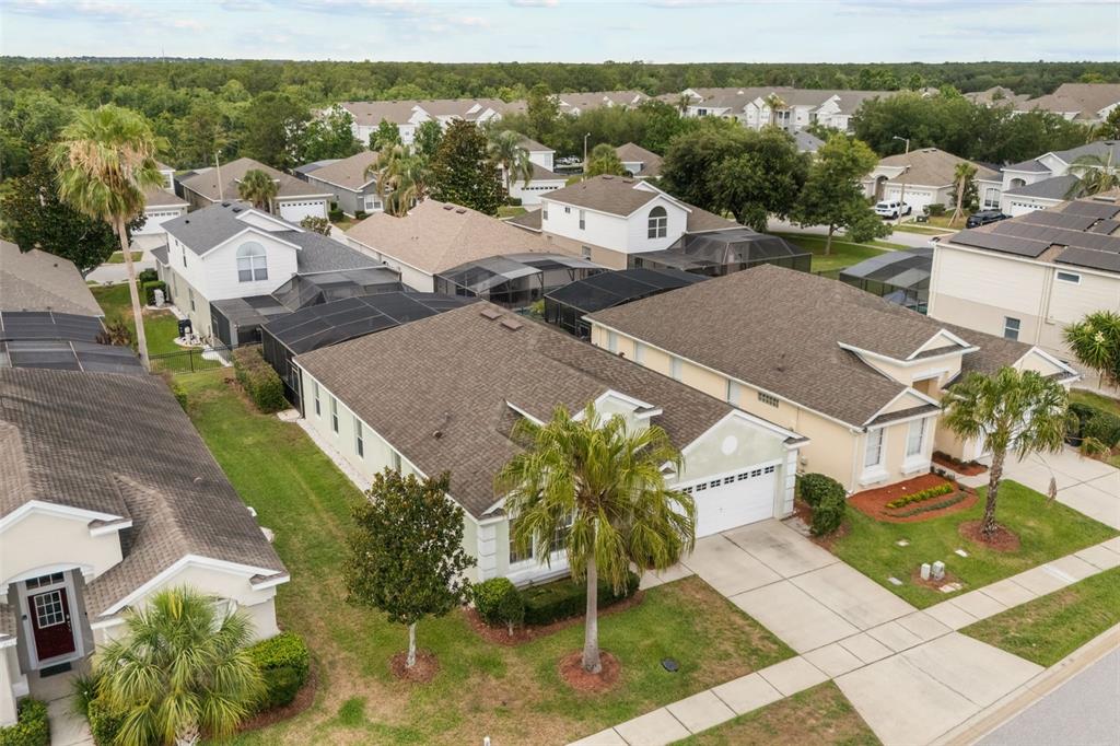 An aerial view shows several suburban houses with brown roofs and screened-in lanais — 2254 WYNDHAM PALMS WAY, KISSIMMEE, FL