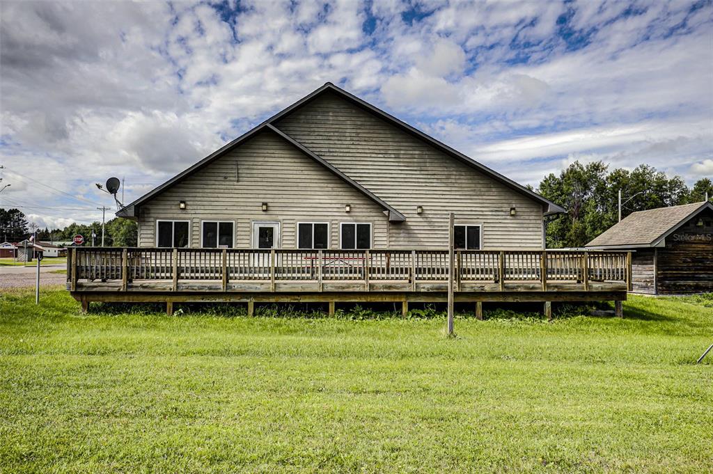 A large, light-colored wooden building features a wide deck and a gabled roof — 255 FAIR AVENUE, MARENISCO, MI