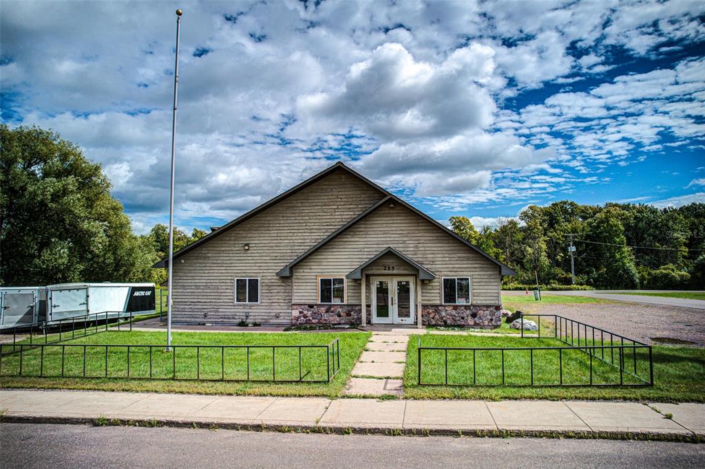 A single-story building with horizontal siding, a stone base, and a central entrance — 255 FAIR AVENUE, MARENISCO, MI